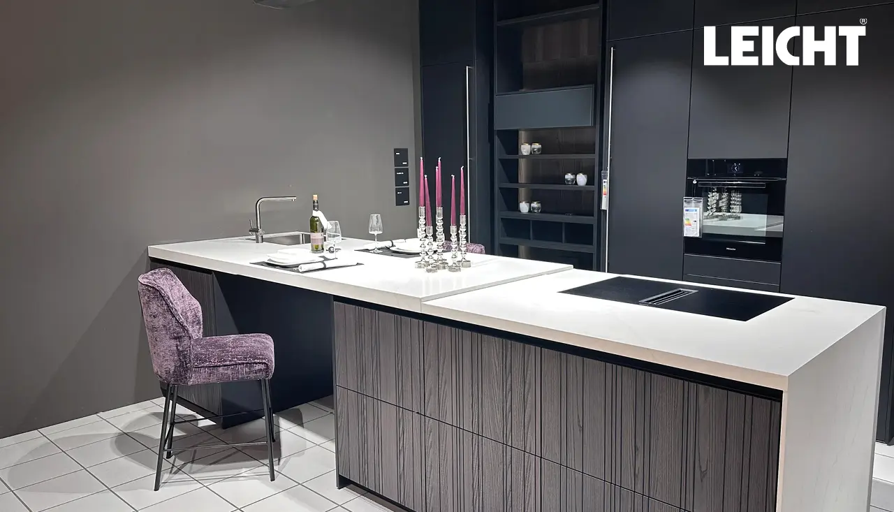 Moderne Leicht Küche in Schwarz mit großer Kochinsel, heller Arbeitsplatte und integrierter Spüle. Elegante Designküche mit Induktionskochfeld, Barhocker und stilvollen Details für hochwertiges Wohnen und Kochen.